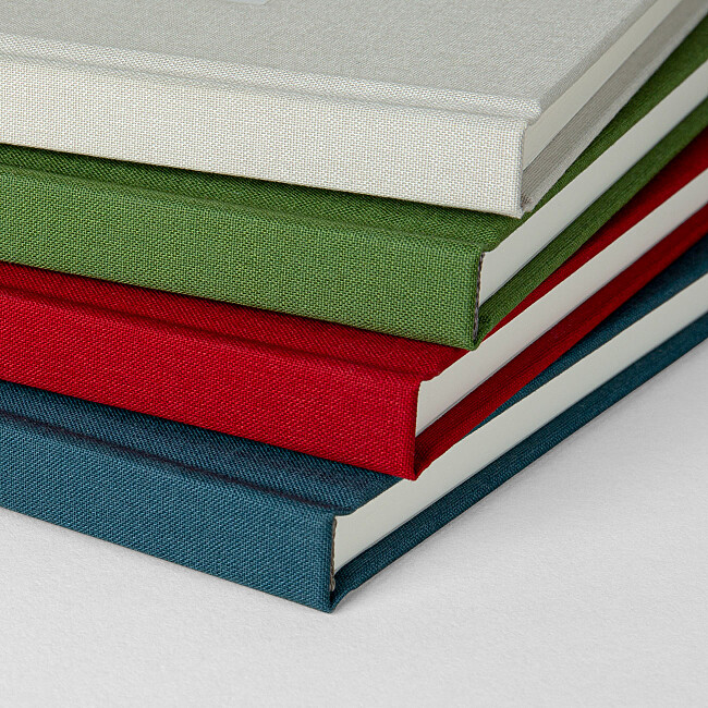 Dos des carnets rouge, vert, beige et bleu Dos des carnets rouge, vert, beige et bleu